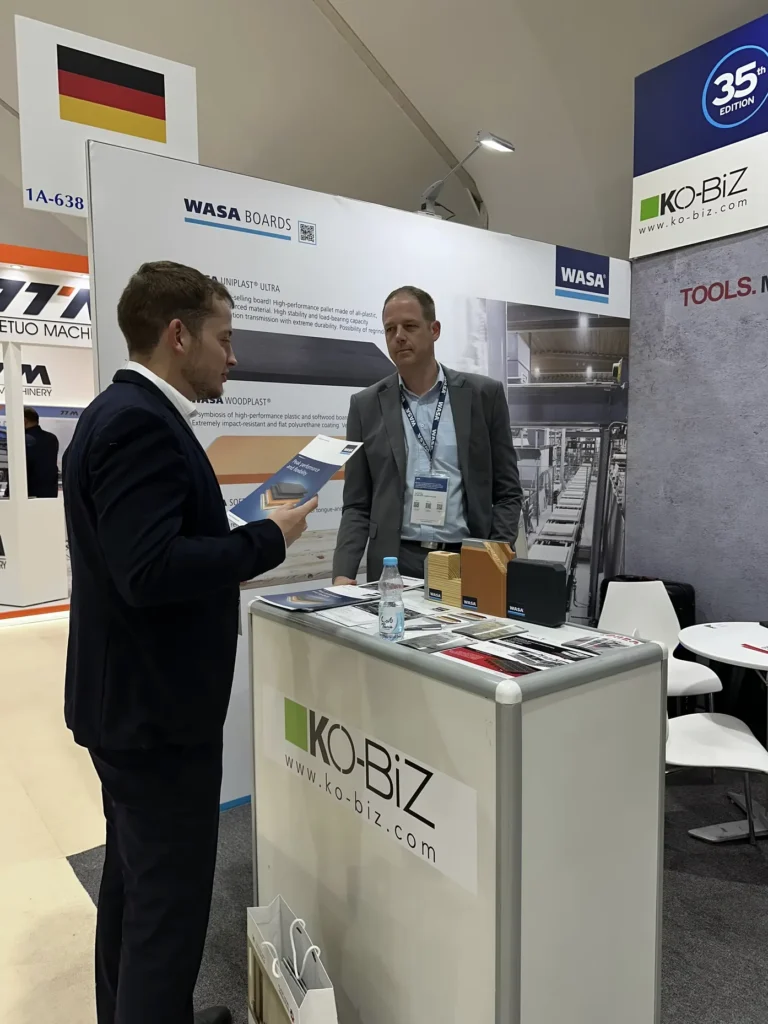 Business representatives discussing building materials at the Saudi Build exhibition.