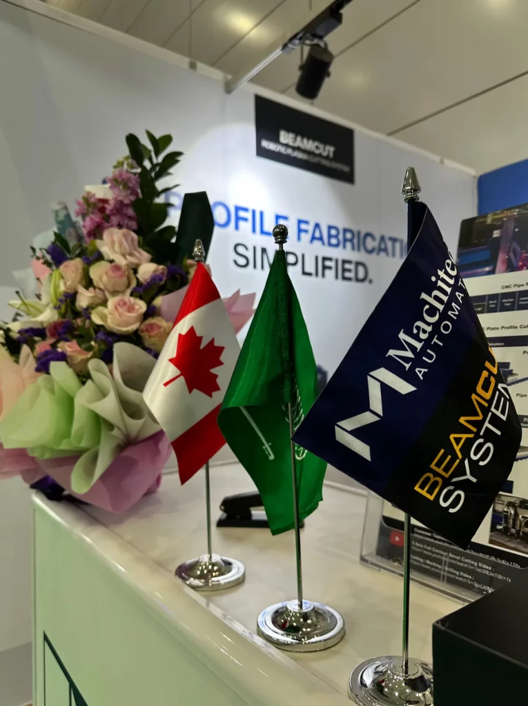 Canadian, Saudi and Machitech flags displayed beside flowers at the exhibition.