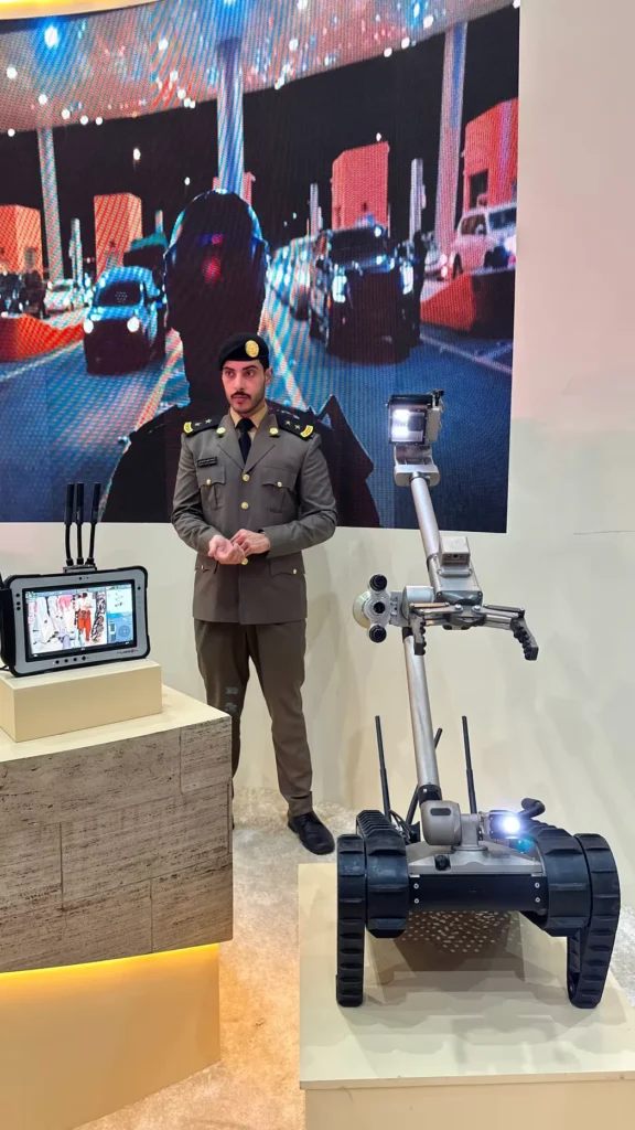 Saudi Civil Defence officer presenting a bomb disposal robot and remote control system.