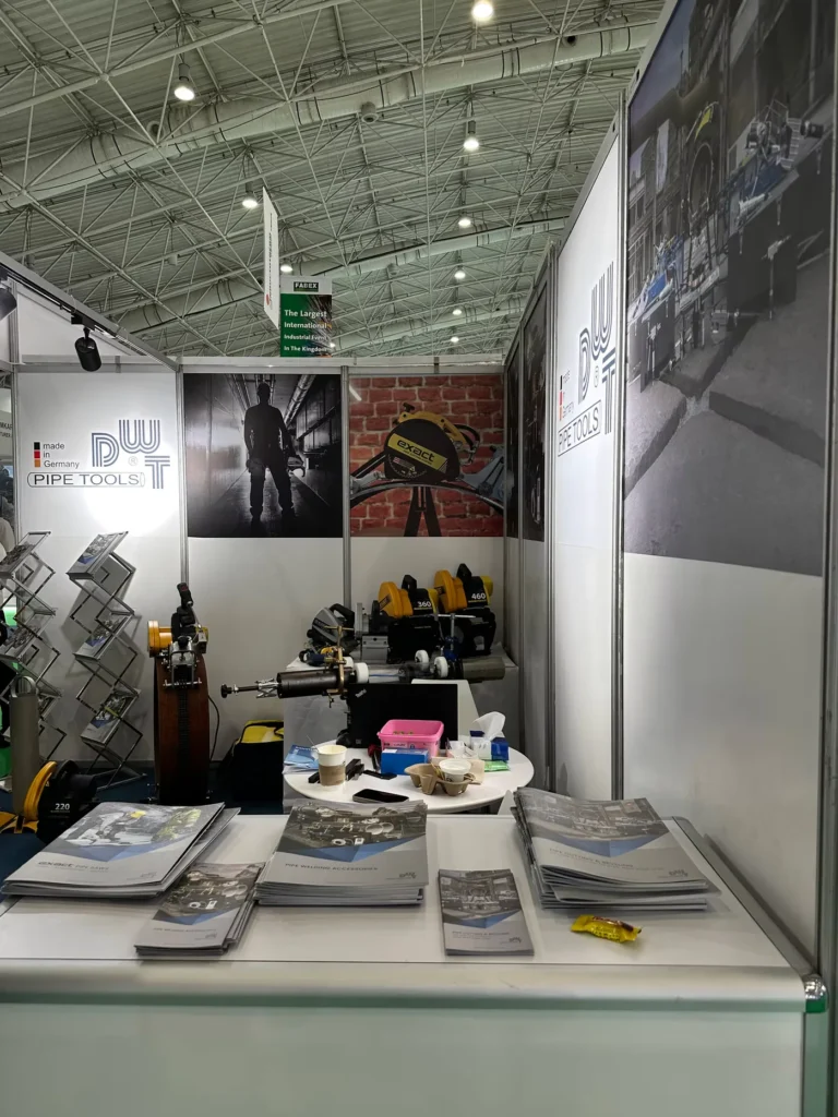 Exact Pipe Tools exhibition stand displaying industrial pipe cutting and welding equipment.