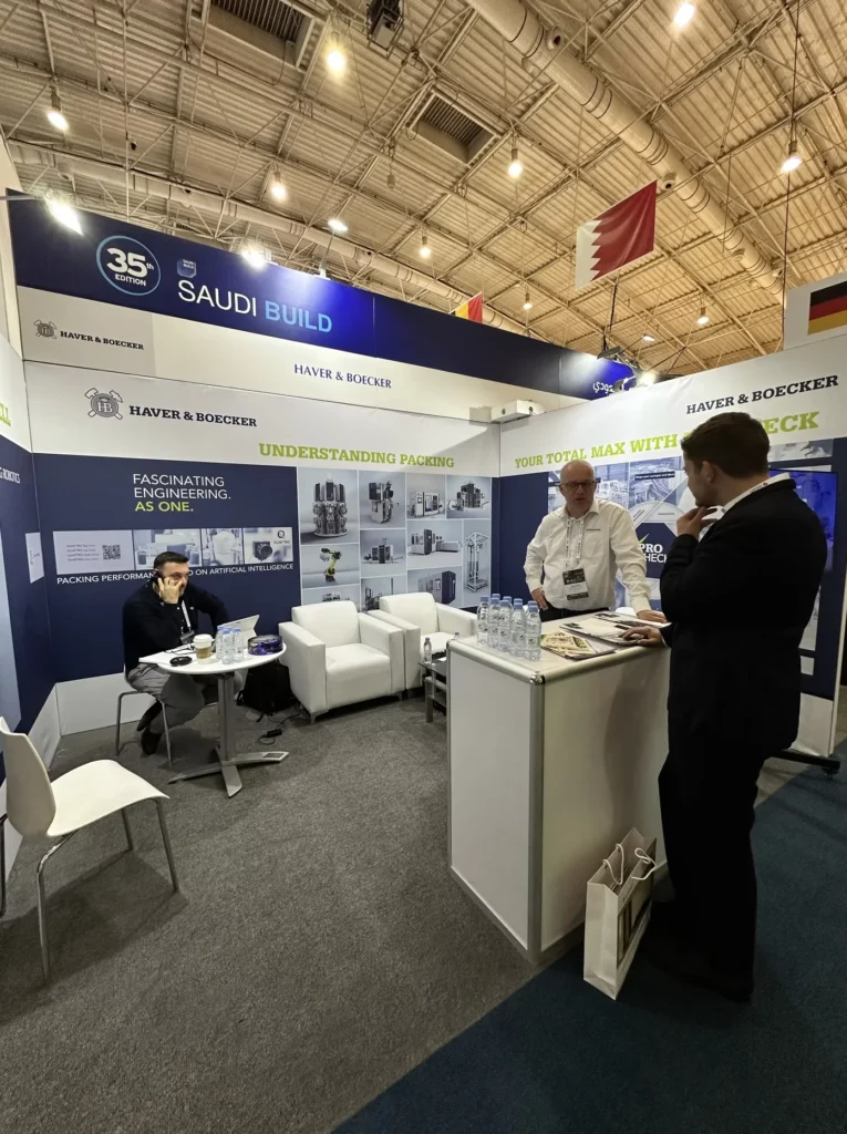 Business discussion at an industrial packaging stand during the Saudi Build exhibition.