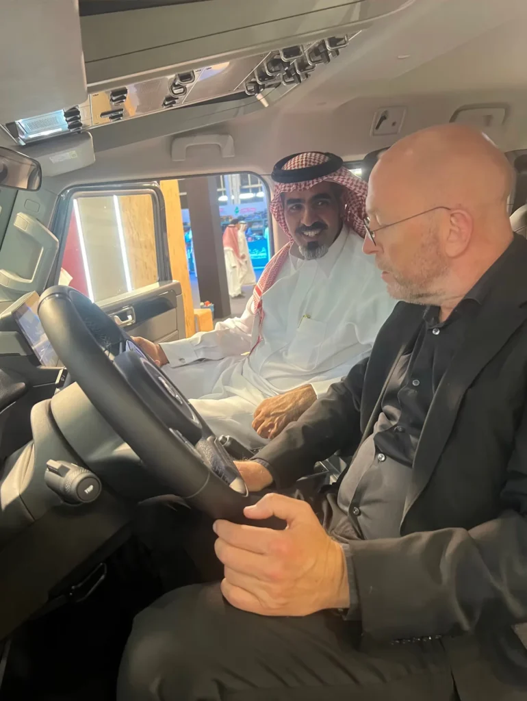 Visitor receiving a demonstration inside an off-road vehicle at the exhibition.