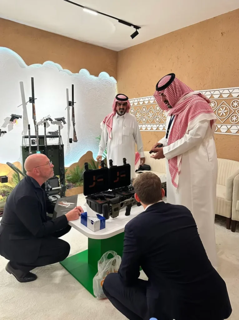 Business meeting around sporting equipment at the Saudi Falcons and Hunting Exhibition.
