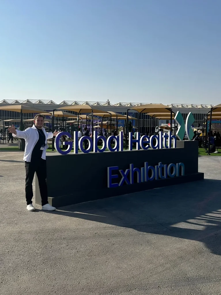 Visitor standing beside the Global Health Exhibition sign in Riyadh.