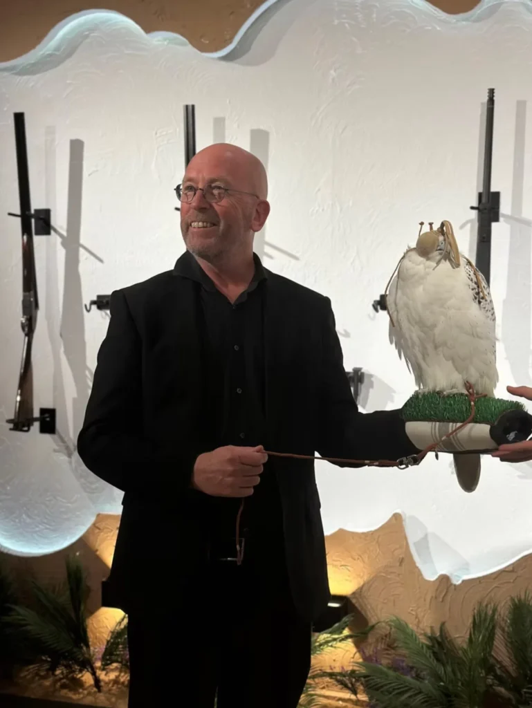 Visitor holding a hooded white falcon during the Saudi Falcons and Hunting Exhibition.